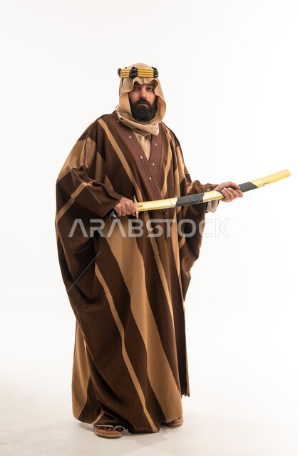 رجل سعودي بالزي التقليدي يحمل سيفاً عربياً