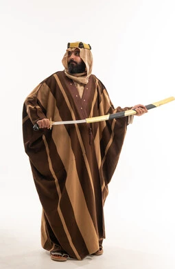 رجل سعودي بالزي التراثي التقليدي يحمل سيفاً عربيًا