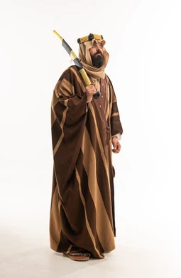 رجل سعودي بالزي التقليدي والبشت يحمل سيفاً في استوديو