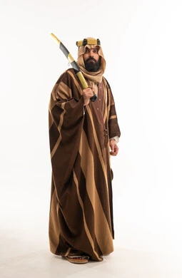 رجل سعودي بالبشت التقليدي يحمل سيفاً