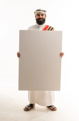 رجل عماني بالزي التقليدي يحمل لوحة بيضاء فارغة
