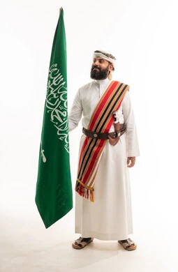 Saudi Man in Traditional Attire Holding Saudi Flag