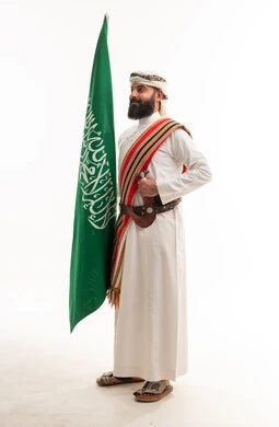 رجل سعودي بالزي الجنوبي التقليدي مع العلم