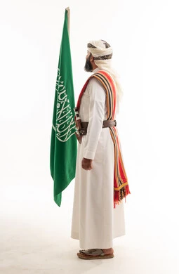 رجل سعودي بالزي الجنوبي التقليدي مع العلم