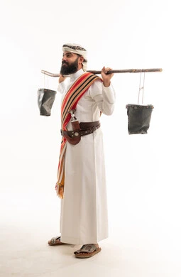 رجل عماني بالزي التقليدي يحمل دلاء الماء