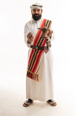 رجل عُماني بالزي التقليدي مع دلة القهوة العربية