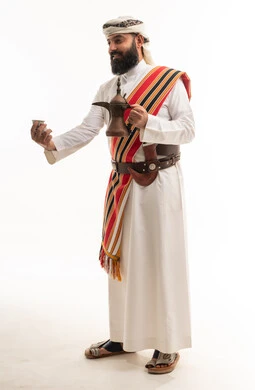 رجل عماني بالزي التقليدي مع دلة قهوة