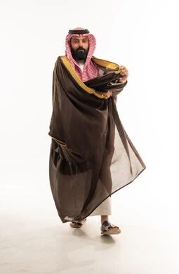 رجل سعودي يرتدي البشت البني التقليدي في الاستوديو