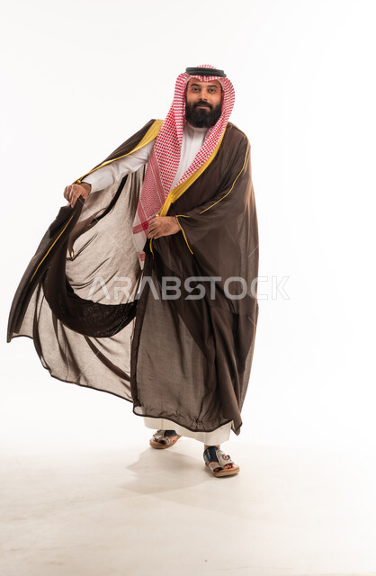 رجل سعودي يرتدي البشت البني التقليدي والشماغ