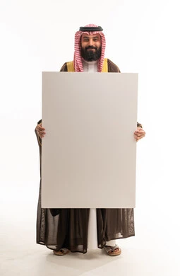 رجل سعودي بالبشت التقليدي يحمل لوحة بيضاء فارغة