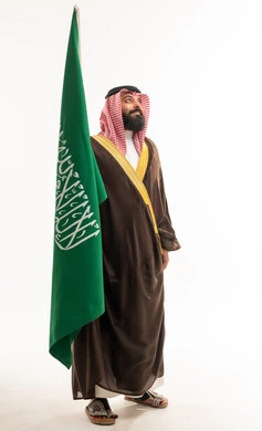 Saudi Man in Traditional Bisht Holding Saudi Flag