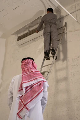 Saudi Man Watching Technician Repairing Air Conditioner