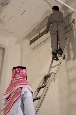 رجل سعودي يشرف على صيانة مكيف هواء داخلي