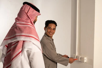 Saudi Man Supervising Asian Electrician Maintenance