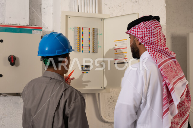 مدير سعودي يشرف على فني عند لوحة الكهرباء