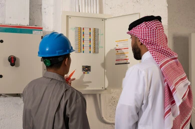 مدير سعودي يشرف على فني عند لوحة الكهرباء