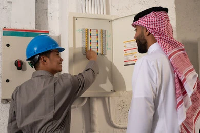 رجل سعودي يشرف على فني كهرباء آسيوي