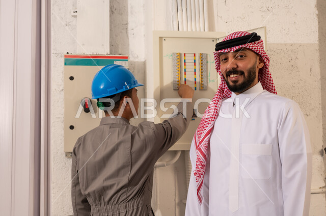 Saudi Man and Electrician Inspecting Electrical Panel