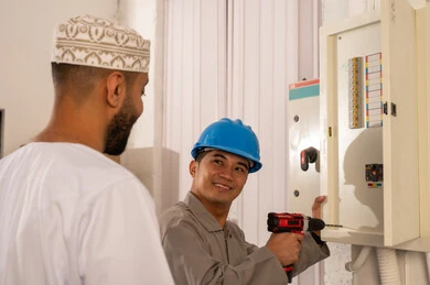 Omani Man and Technician Working on Electrical Panel