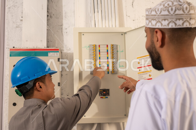 Omani Man and Technician Inspecting Electrical Panel