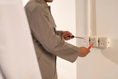فني كهرباء يقوم بإصلاح مقبس الحائط