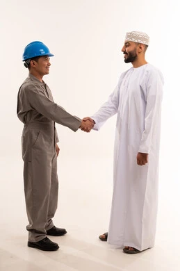 Omani Businessman and Asian Worker Shaking Hands