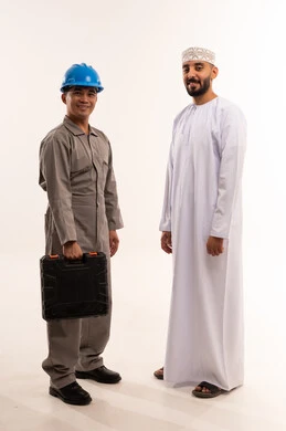 رجل عُماني وفني آسيوي مع حقيبة أدوات في الاستوديو