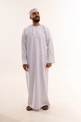 رجل عماني بالزي التقليدي أمام خلفية بيضاء