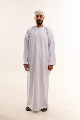 رجل عُماني بالدشداشة والكمة التقليدية في الاستوديو