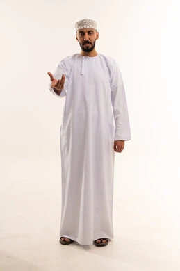 رجل عُماني بالزي التقليدي يمد يده في استوديو