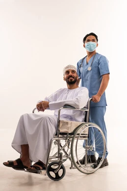 مريض عماني على كرسي متحرك مع ممرض آسيوي