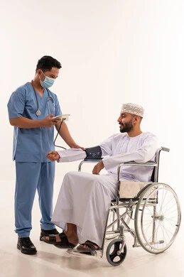 Nurse Checking Omani Patient Blood Pressure in Wheelchair