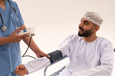 قياس ضغط الدم لرجل عماني على كرسي متحرك