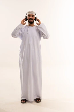 رجل عماني بالزي التقليدي يستخدم سماعات الرأس