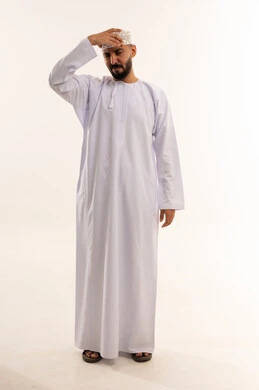 رجل عماني بالزي التقليدي يشعر بالتعب والإجهاد