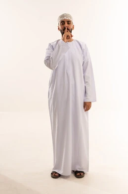 Omani Man Shushing in Traditional Dishdasha and Kumma
