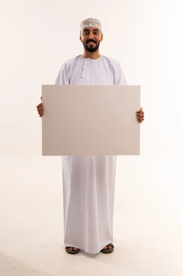 رجل عماني يحمل لوحة إعلانية بيضاء فارغة