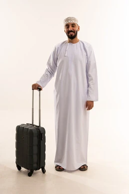 رجل عماني بالزي التقليدي مع حقيبة سفر