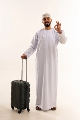 رجل عماني مع حقيبة سفر يشير بعلامة الموافقة