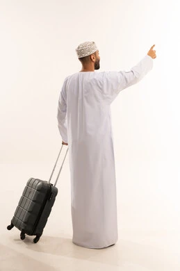 رجل عماني بزي تقليدي مع حقيبة سفر