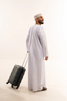 Omani Man in Traditional Dress with Suitcase