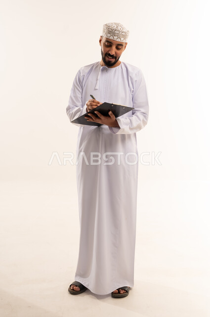 Omani Man Writing on Clipboard in Traditional Dress