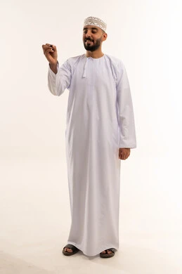 رجل عماني بالزي التقليدي يكتب على خلفية بيضاء