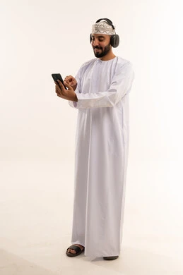 Omani Man Using Smartphone with Headphones Studio Shot
