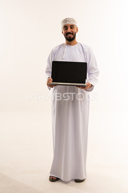 Omani Man in Traditional Dress Holding Laptop Computer