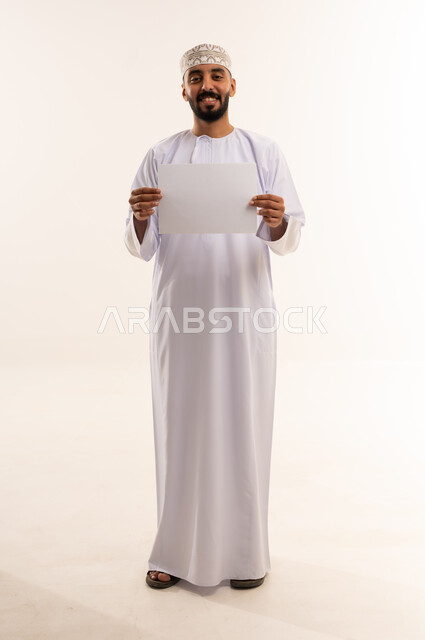 Omani Man in Traditional Dress Holding Blank Sign