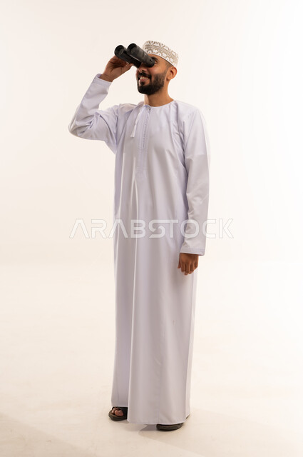 رجل عماني بالزي التقليدي ينظر من خلال المنظار