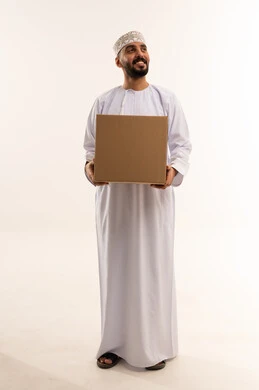 رجل عُماني يحمل صندوق شحن كرتوني بخلفية بيضاء