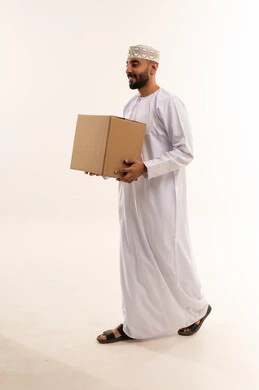 رجل عماني يحمل صندوق شحن على خلفية بيضاء
