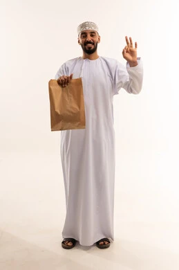 رجل عُماني يمسك حقيبة ورقية وعلامة موافق